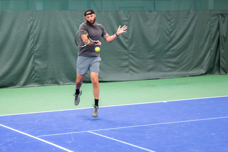 Player running to hit a forehand on the indoor courts