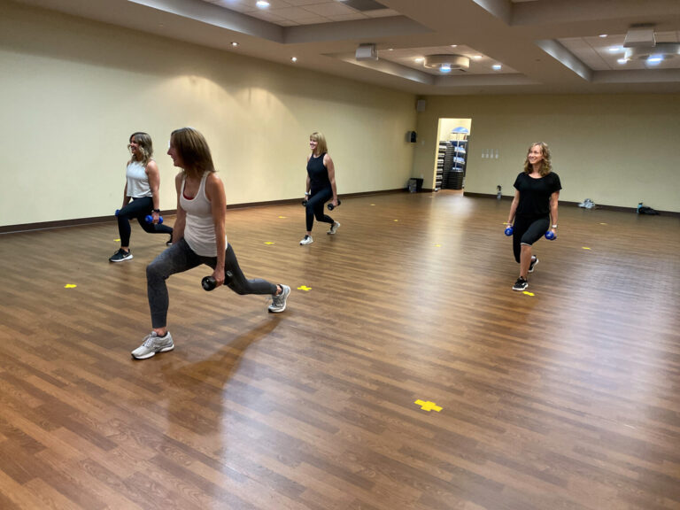 Group exercise class doing lunges in the studio