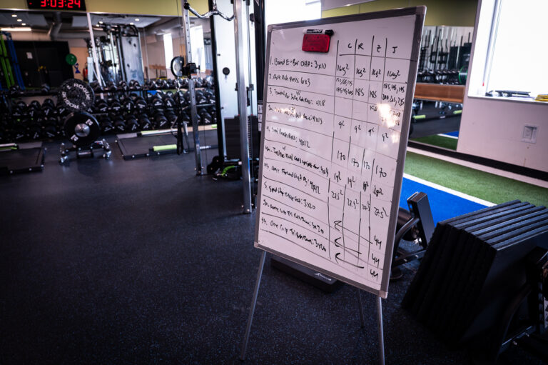 Performance Lab whiteboard workout next to the weight racks